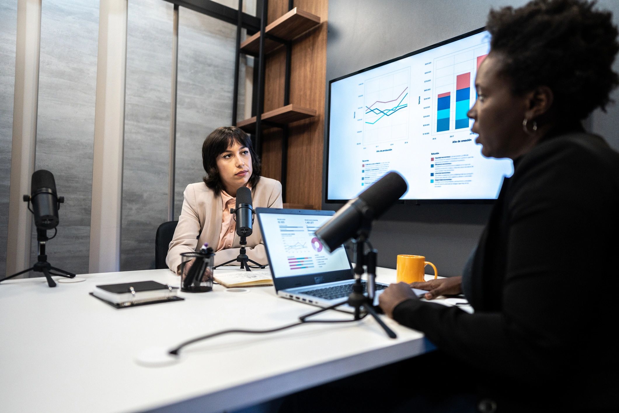Two people recording an interview in a studio setting