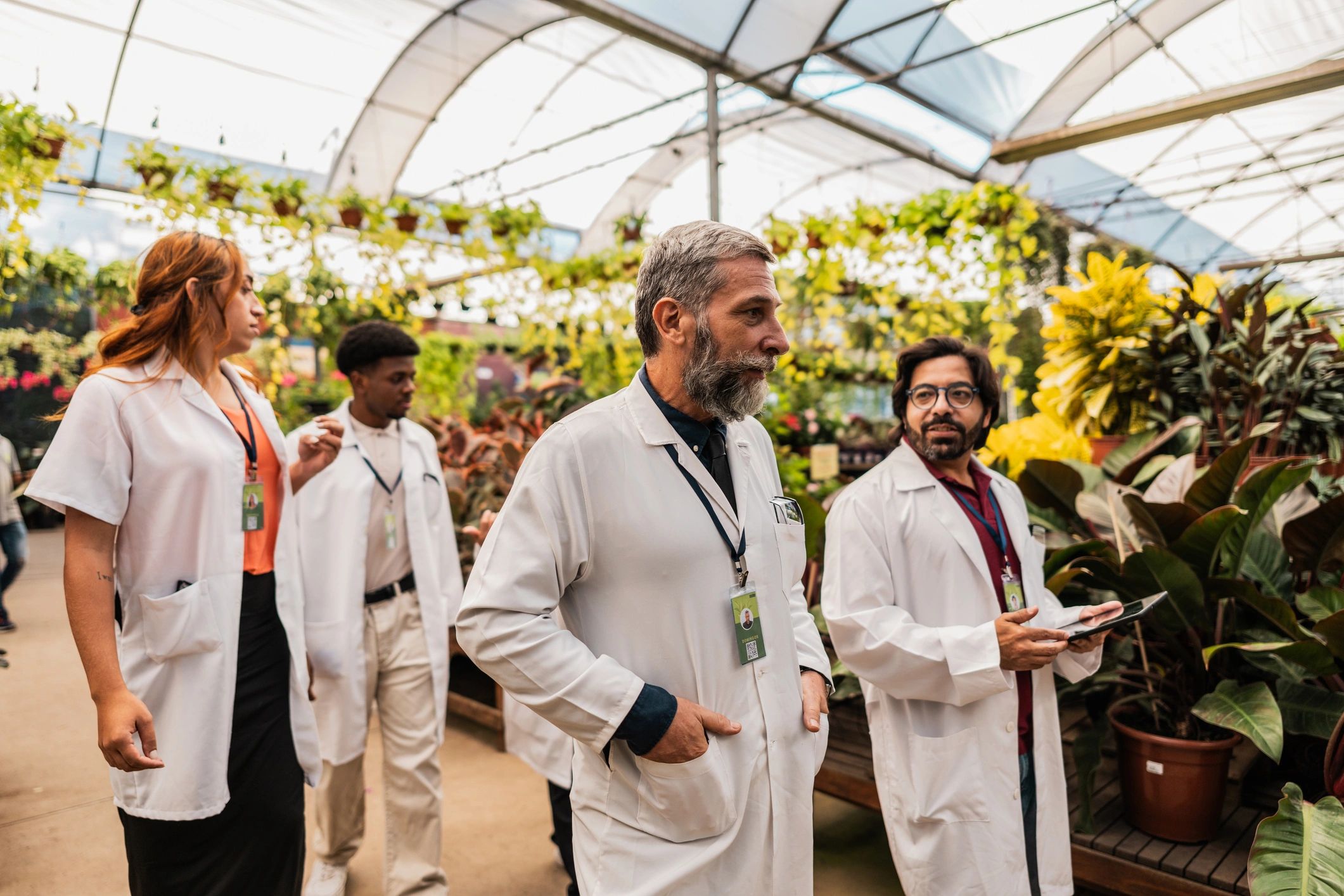 Agricultural engineers walking and discussing in a greenhouse