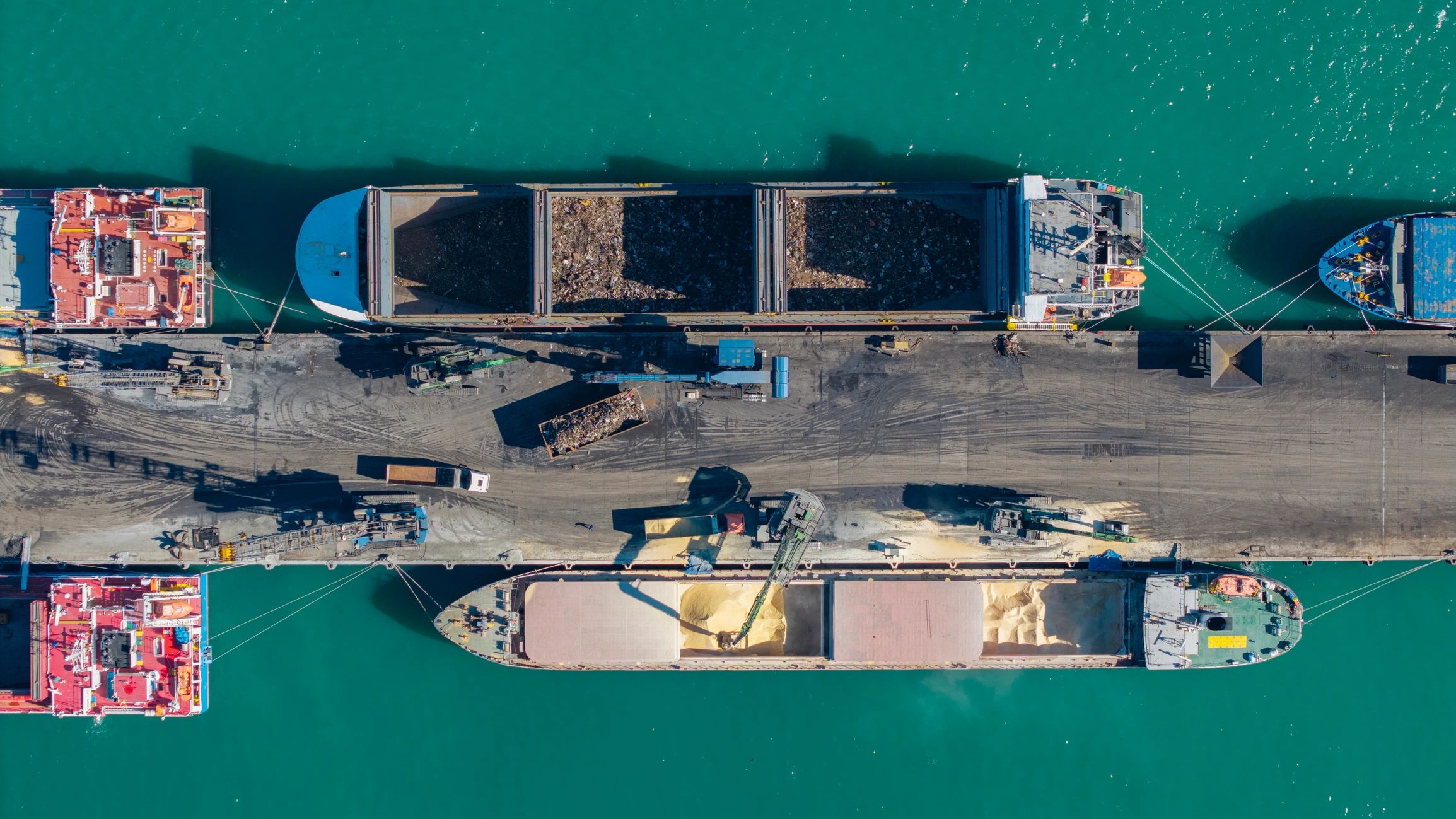 Cargo ships loading bulk commodities at a port terminal
